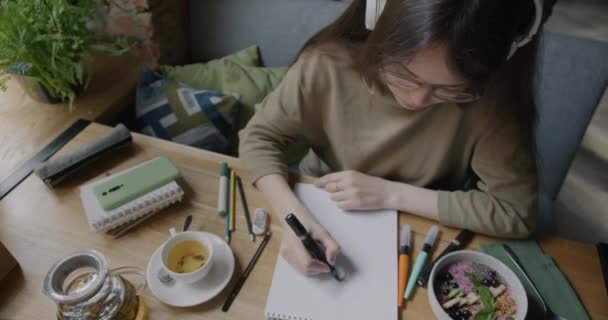 Portrait Creative Woman Wearing Headphones Drawing Marker Paper Listening Music — Stock Video