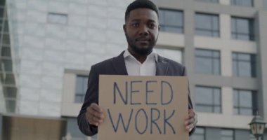 İşsiz Afro-Amerikan bir adamın portresi. Elinde 
