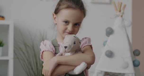 カメラを見て笑っている巨大なぬいぐるみの家に立つ愛らしい子供のスローモーションポートレート 幸せな子供時代と感情の概念 — ストック動画