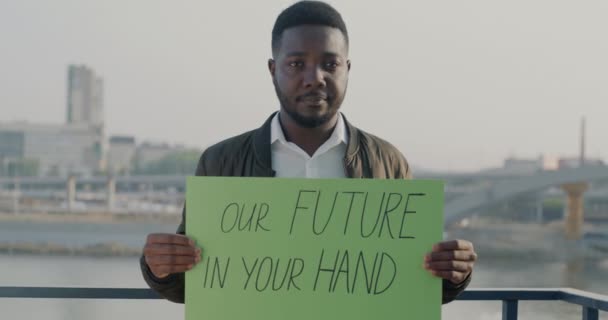 Retrato Hombre Afroamericano Serio Sosteniendo Nuestro Futuro Bandera Mano Pie — Vídeo de stock