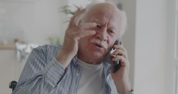 Emocjonalny Starzec Rozmawiający Przez Telefon Komórkowy Gestykulujący Mieszkaniu Technologia Łączności — Wideo stockowe