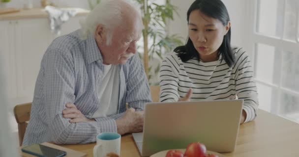 Asijská Dáma Správce Mluvit Důchodcem Muže Pomocí Notebooku Společně Pomáhá — Stock video