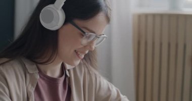 Ofiste çalışan, kulaklıkla müzik dinleyen ve grafik tabletleriyle resim çizen neşeli genç bir kadın. Yaratıcı meslek ve modern sanat konsepti.