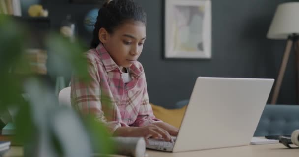 自宅で屋内で宿題をするノートパソコンのタイピングで働くスマート中東の女の子 現代の技術とインテリジェントな子供の概念 — ストック動画
