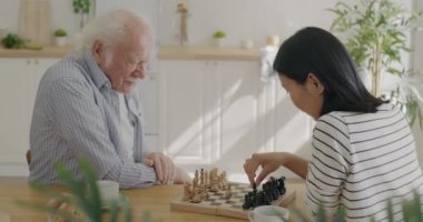 Genç bir kadın mutfakta yaşlı bir adamla satranç oynamaya gönüllü oluyor. Birlikte vakit geçirmenin tadını çıkarıyorlar. Emeklilik ve masa oyunları konsepti.