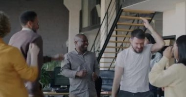 Ofis partisinde rahat rahat dans eden kaygısız genç iş arkadaşları. Şirket etkinliği ve tatil kutlamaları konsepti.