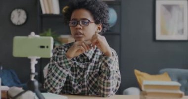 Evdeki akıllı telefon kamerasıyla sosyal medya için video kaydeden Afrikalı Amerikalı genç çocuk portresi. Çocukluk ve vloglama kavramı.