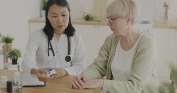 Mulher Asiática Médico Examinando Paciente Sênior Feminino Verificando Saturação Oxigênio — Vídeo de Stock