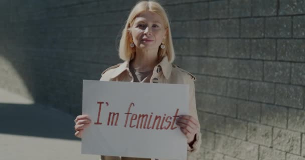 Portrait Ralenti Femme Mature Tenant Signe Féministe Souriant Debout Extérieur — Video