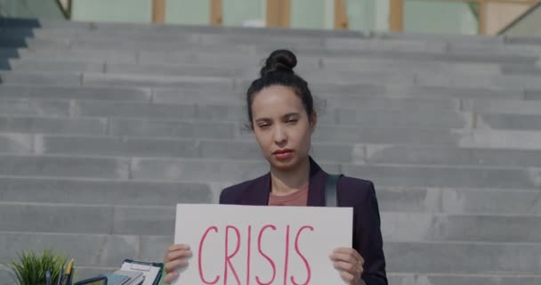 不快乐的女商人举着危机横幅坐在封闭的办公中心楼梯上的画像 失业和衰退概念 — 图库视频影像