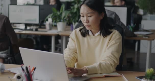 Allvarlig Asiatisk Affärskvinna Med Hjälp Bärbar Dator Och Skriva Information — Stockvideo