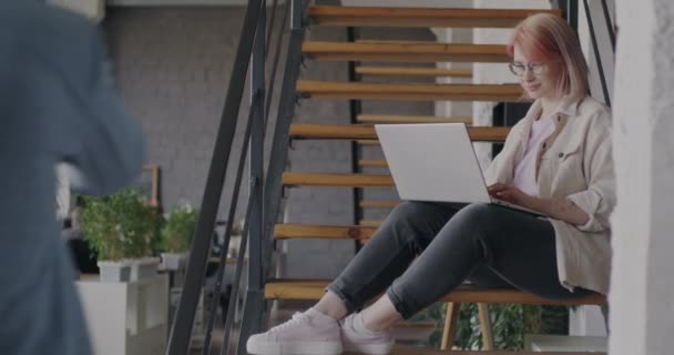 Vrolijke Jonge Werknemer Met Behulp Van Laptop Zittend Trap Gedeeld — Stockvideo