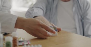 Oksijen doygunluğu ölçer ve evdeki hastayı kontrol eden doktorların yakın çekimleri. Sağlık ve modern teknoloji kavramı.