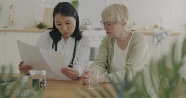 Γιατρός Και Ηλικιωμένη Γυναίκα Ασθενής Διαβάζοντας Ιατρικά Έγγραφα Κατά Διάρκεια — Αρχείο Βίντεο