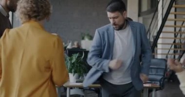 Şirket etkinliğini kutlamak için iş arkadaşlarıyla dans eden neşeli iş adamlarının yavaş çekimleri. Mutlu insanlar ve işyeri eğlence konsepti.