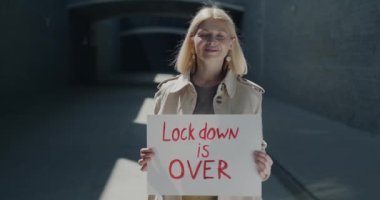 Kilitli tutulan mutlu yetişkin iş kadınının portresi güneşli bir günde açık havada salgının sonunun keyfini çıkartıyor. İnsanlar ve covid-19 salgın konsepti.