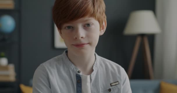 アパート内のカメラを屋内で見て赤い髪をした10代の少年の肖像画 幸せな子供時代と肯定的な感情の概念 — ストック動画