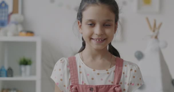 親指アップの手のジェスチャーと笑顔を示す幸せな少女の肖像画は自宅で満足を表現しています 幸せな子供時代と人間の感情表現の概念 — ストック動画