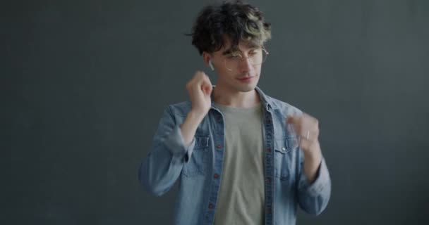Hombre Joven Usando Auriculares Inalámbricos Escuchando Música Bailando Divirtiéndose Sobre — Vídeo de stock
