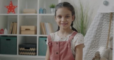 Neşeli genç kız portresi gülümseyen el sallayarak evden çevrimiçi video görüşmesi yapıyor. İletişim ve çocuk konsepti.