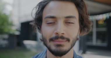 Yazın açık havada kameraya bakan neşeli Orta Doğulu adamın yakın plan portresi. Gençler ve olumlu duygu kavramı.