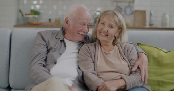 Porträt Eines Schönen Seniorehepaares Das Lachend Auf Der Couch Sitzt — Stockvideo