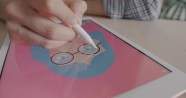 Dijital sanatçının masadaki kadın yüzünü çizen grafik tabletli bir resim oluşturduğu yakın plan. Modern teknoloji ve tasarım konseptinde kariyer.