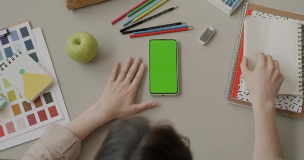 Widok Góry Młodej Kobiety Dotykającej Szkicownika Patrzącej Smartfona Zielonym Ekranem — Wideo stockowe