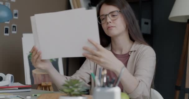 Zamyślona Młoda Dama Projektantka Patrząc Ilustracje Myśląc Sztuce Siedzącej Przy — Wideo stockowe