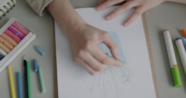 Çizim defterinde çizim bitkisi olan kadın elinin yakın plan fotoğrafı. Masada çalışıyor ve hobi olarak eğleniyor. Sanat ve yaratıcı aktivite kavramı.
