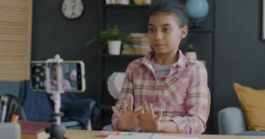 Yaratıcı Ortadoğulu genç vlogger video kaydedicisi akıllı telefon kamerasıyla konuşuyor ve evde el kol hareketi yapıyor. Sosyal medya ve çocukluk kavramı.