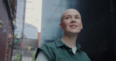 Güzel şehri seyreden ve yaz günü gülümseyen genç bir kadın turistin yavaş çekimde portresi. Tatil ve gezi konsepti..