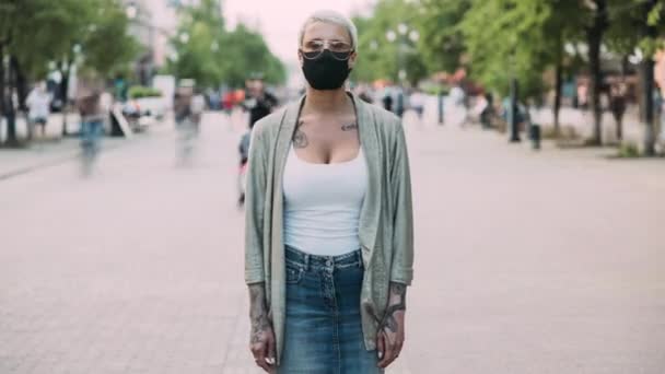 流行期に街に立つ医療用マスクや眼鏡の若い女性のタイムラプスの肖像画 流行病と世界的な健康危機の概念 — ストック動画