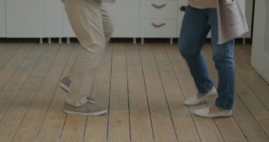 Neşeli yaşlı adam ve kadın dans ediyor ve gülüyor mutfakta dinleniyor. Mutlu emeklilik ve ev içi faaliyet kavramı.