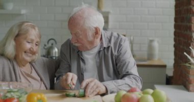 Son sınıf öğrencisinin salata pişirmesi sebze kesmesi ve evde mutlu bir eş beslemesi. Aile yaşam tarzı ve ilişki kavramı.