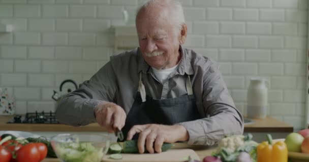 陽気退職者家庭でのキッチンでの食事の準備に焦点を当てた昼食のための野菜サラダを調理します 食と退職の考え方 — ストック動画