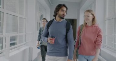 Üniversite koridorunda yürüyen ve kahve içmek için içen kadın ve erkek öğrencilerin Dolly 'si. Gençlerin sosyalleşmesi birlikte eğlenmeleri.