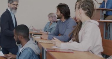 Sınava hazırlanan öğrencilere sınav kağıtları veren lise öğretmeni. Modern eğitim ve sınav hazırlama kavramı.
