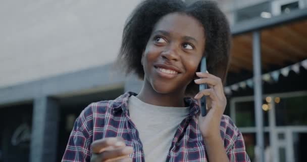 Şehir Caddesinde Cep Telefonuyla Konuşan Neşeli Afrikalı Amerikalı Kız Öğrenci — Stok video
