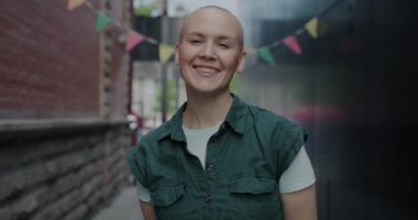 Açık havada duran ve şehir caddesinde gülümseyen mutlu genç bir kadının portresi. Neşeli gençler ve şehir yaşam tarzı konsepti.