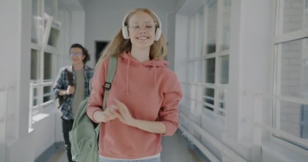 Долли Сняла Радостную Молодую Блондинку Наушниках Гуляющую Студенческом Лобби Развлекающуюся — стоковое видео