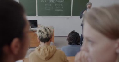 Bir grup öğrenci üniversite sınıfında İngilizce dili öğrenen bir İngilizce öğretmeni dinliyor. Eğitim ve dil bilimi kavramı.