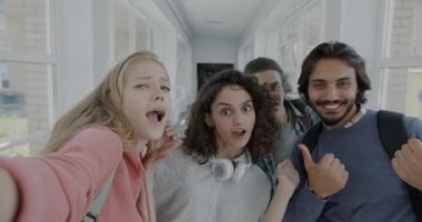 Bir grup öğrenci fotoğraf çektirip kameraya bakıp gülüyor ve üniversite salonunda eğleniyorlar. Modern yaşam tarzı ve fotoğraf konsepti.