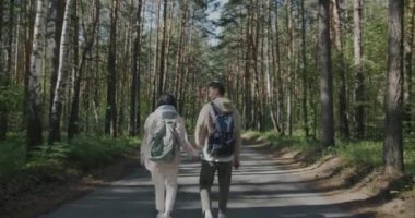 Sırt çantalı genç ve güzel bir çift güneşli yaz gününde ormanda doğanın tadını çıkarıyorlar. Romantik ilişki ve turizm kavramı.