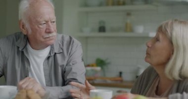 Mutlu son sınıflar kahvaltının tadını çıkarıyorlar. Kahve içip, modern mutfakta sohbet ediyorlar. Aile hayatı ve yemek konsepti.