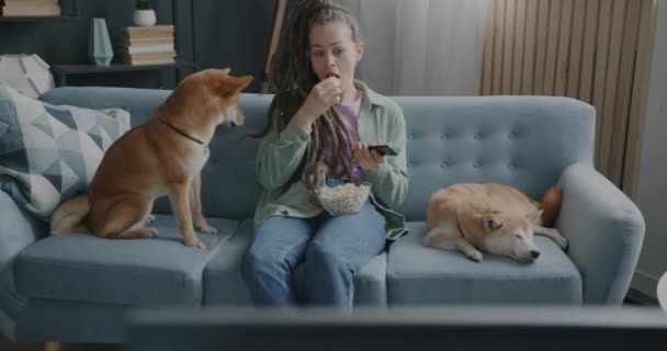 Jovencita Viendo Televisión Comiendo Palomitas Acariciando Mascotas Dos Perros Shiba — Vídeo de stock