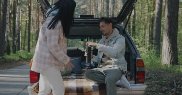 丈夫和妻子喝着热水瓶里的茶 坐在车里聊天 在森林里享受旅程 旅游和运输概念 — 图库视频影像