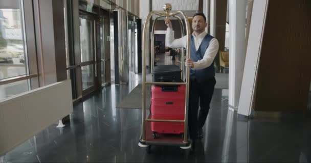 Hotel Porter Φορώντας Στολή Πιέζει Καλάθι Αποσκευών Βαλίτσες Πόδια Στο — Αρχείο Βίντεο