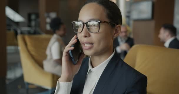 会話で忙しいホテルのホテル内の携帯電話で仕事の話をしています 人々と近代的な技術の概念 — ストック動画