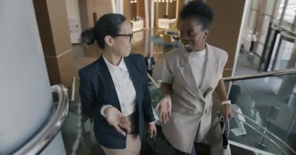 Kolegyně Kráčející Schodech Moderní Hotelové Hale Mluvící Úsměvem Užívající Neformální — Stock video